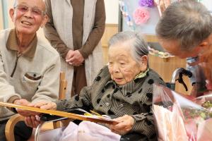 受け取った褒賞状を見つめる田中さん