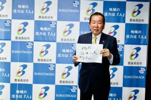 佐々木市長がメッセージボードを手に持っている写真