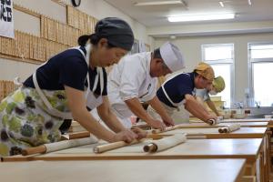 そばを打っている受験者たちの写真