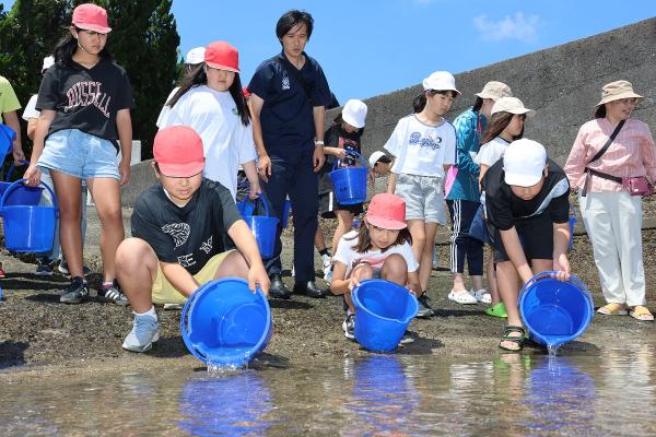 ガザミを放流する小学生