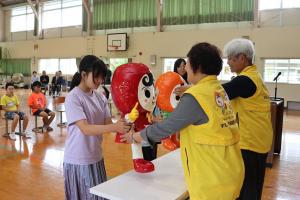 ぬいぐるみを受け取る児童の写真