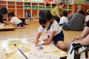 描いた絵に色を塗っている園児の写真
