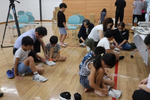 新聞紙でスリッパを作っている写真