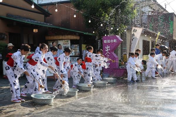 打ち水をしている浴衣姿のこどもたちなどの写真