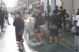 ペットボトルで水を撒いている子どもたちの写真
