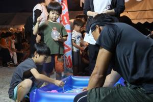 夜市でヨーヨー釣りを楽しむ子どもたち