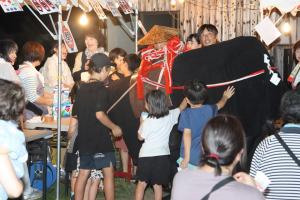 夜市会場に来た張り子の牛を触るお客さん