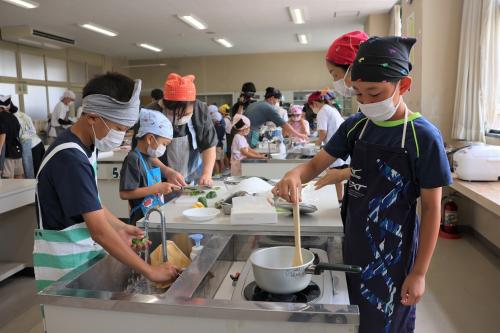調理をしている参加者たちが多数写っている写真