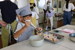 ゼリーの材料を注ぎ分けている子どもの写真