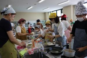 お弁当箱に具材をつめてたり、調理のしあげをしている参加者たちの写真