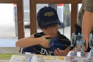 プラモデルの部品を枠から外している子どもの写真