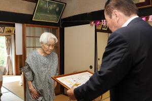褒賞状とお祝い金を渡しているときの写真