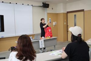 非常用持ち出し袋の中身を説明している講師と話を聞いている参加者の写真