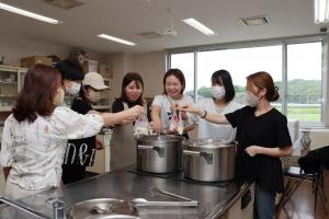 準備したお米を鍋にいれている参加者たちの写真