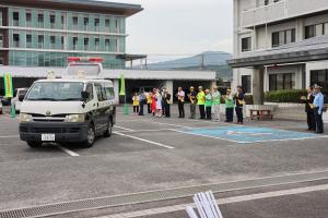 出発する警察車両を見送る参加者