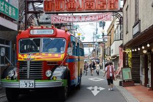 商店街に展示されているボンネットバスの商店街の人混みの写真