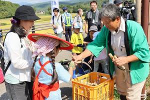 鎌を受け取る参加者