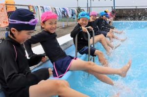 低学年の児童たちがバタ足の練習をしている写真