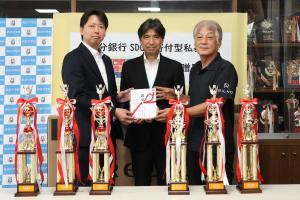 高田中学校の小川匡校長、株式会社田中工藝の田中賢二代表取締役社長、大分銀行高田支店の安部萬治郎支店長の集合写真
