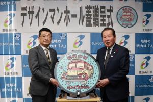 デザインマンホール蓋を真ん中にした記念写真