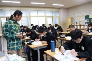 問題を解いている生徒たちとその様子を見ている講師の写真