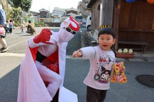 だがしを持った子どもと昭和仮面の写真