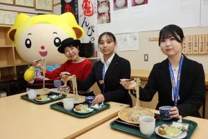 試食をしている観光アンバサダーなどの女性とキャラクターの写真