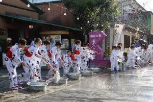 打ち水をしている浴衣姿のこどもたちなどの写真